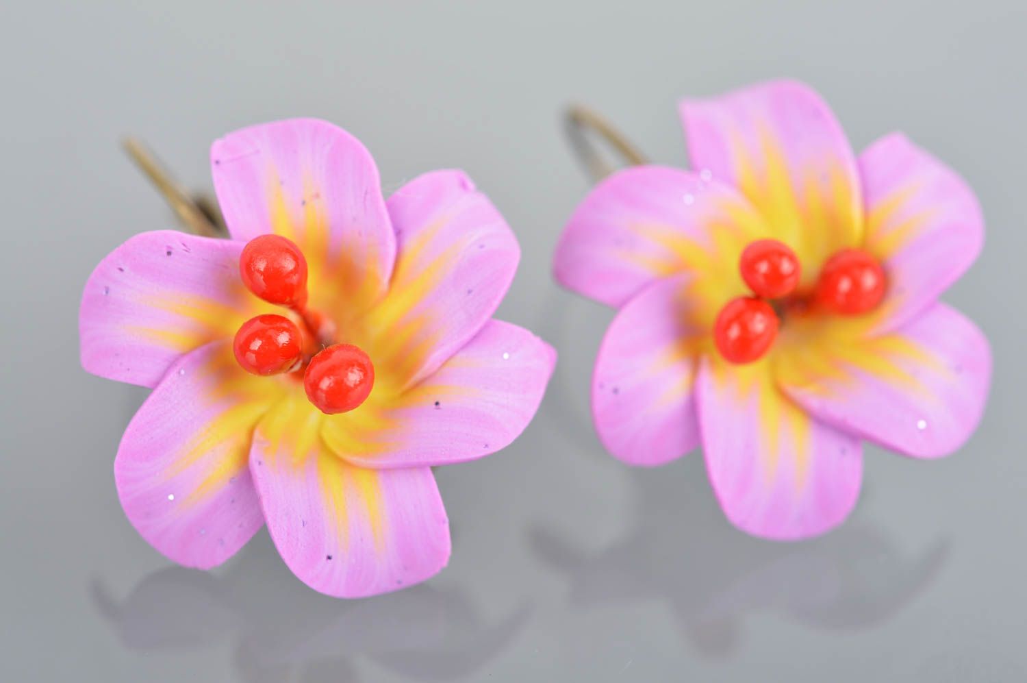 Feine violette originelle handgemachte Ohrringe aus Polymerton mit Blumen foto 2
