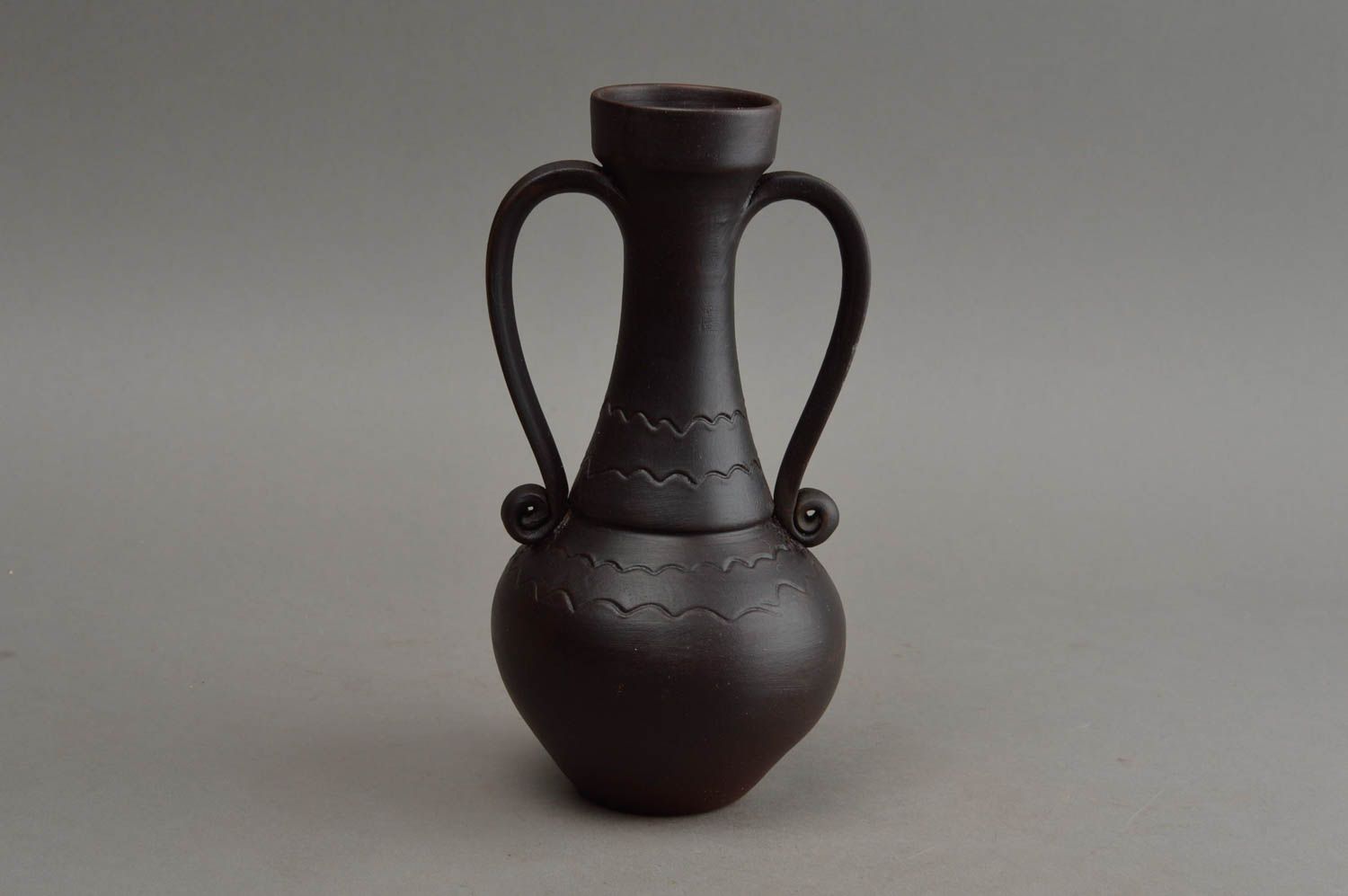Schwarze handgemachte Vase aus Ton mit Musterung und zwei gedrehten Griffen foto 2