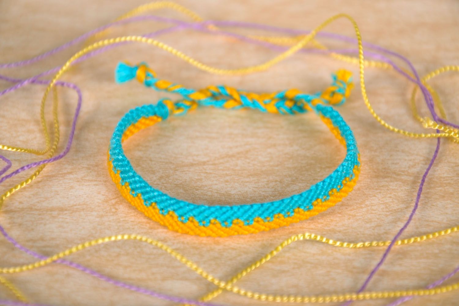 Bracelet tressé en fils jaunes et bleus photo 1
