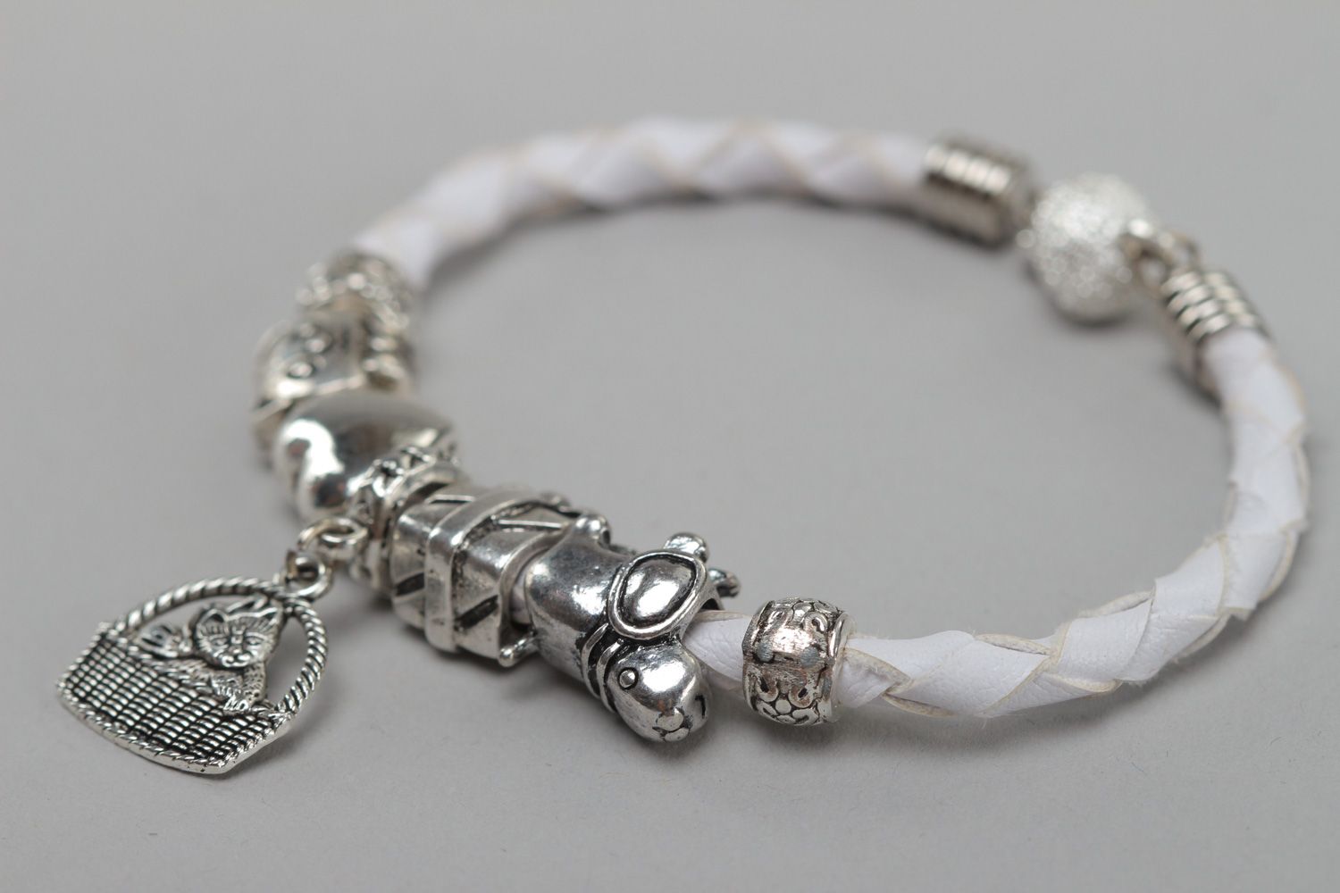Handmade wrist bracelet woven of faux leather of white color with metal charm photo 2