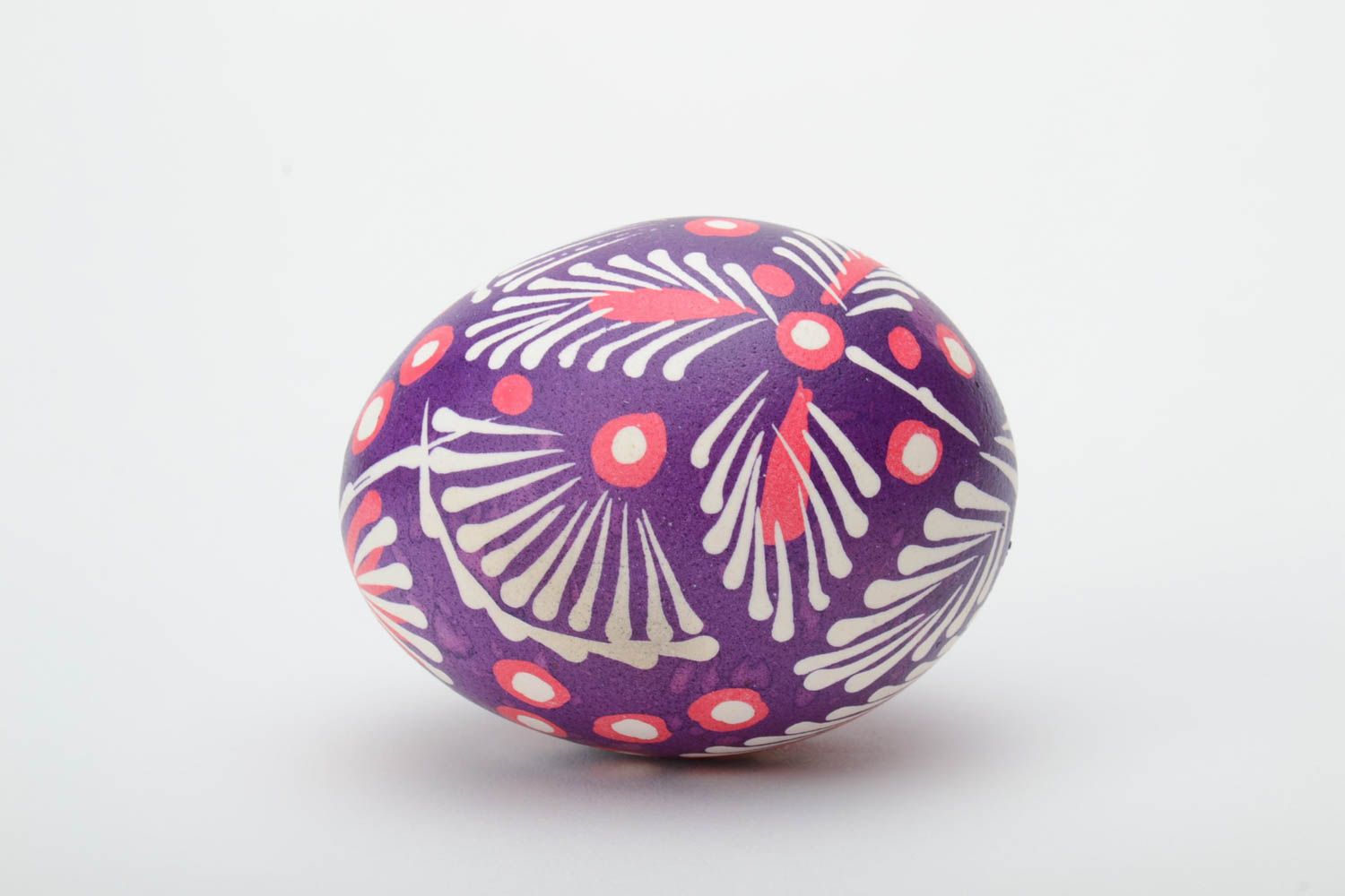 Huevo pintado arteanal en la técnica lemkivska con ornamentos de colores blanco y violeta foto 3