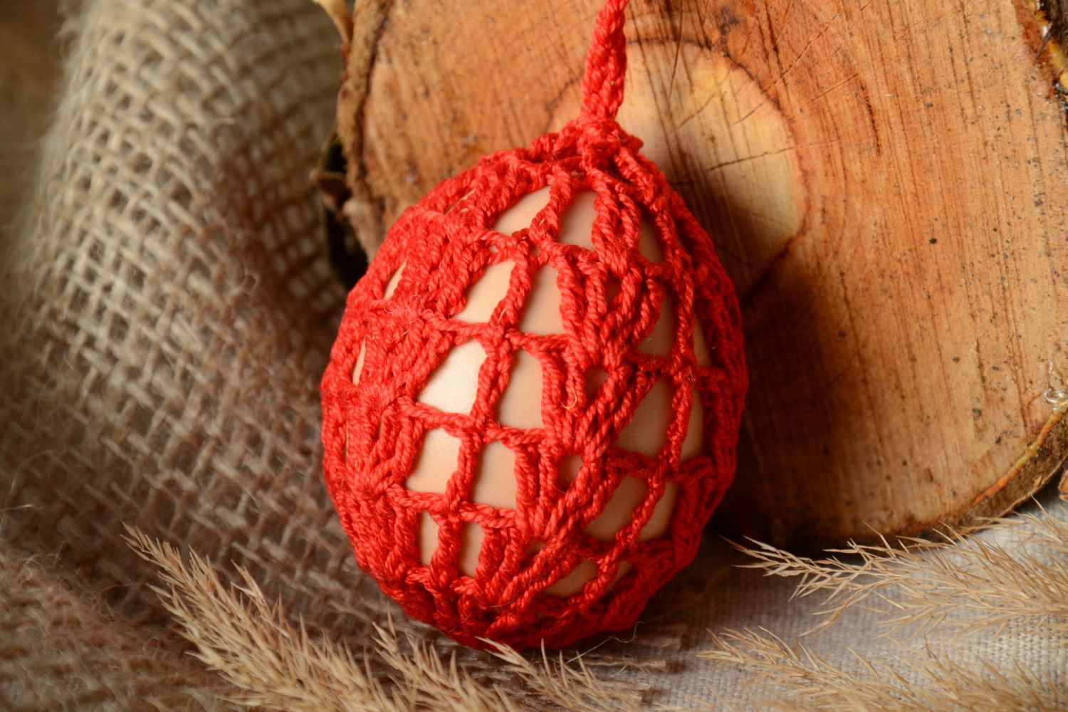 Homemade red decorative Easter egg woven over with threads photo 1