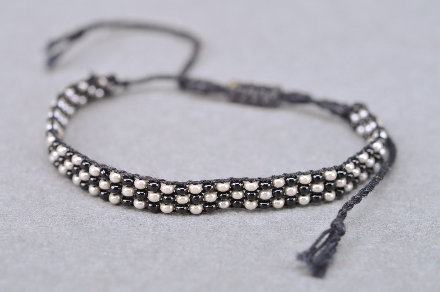 Handmade wrist bracelet woven of black and nacre beads with ties for women photo 2