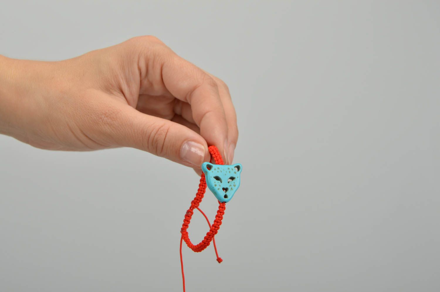 Bracelet rouge fin tressé en fil ciré fait main avec tête de panthère bleue photo 2