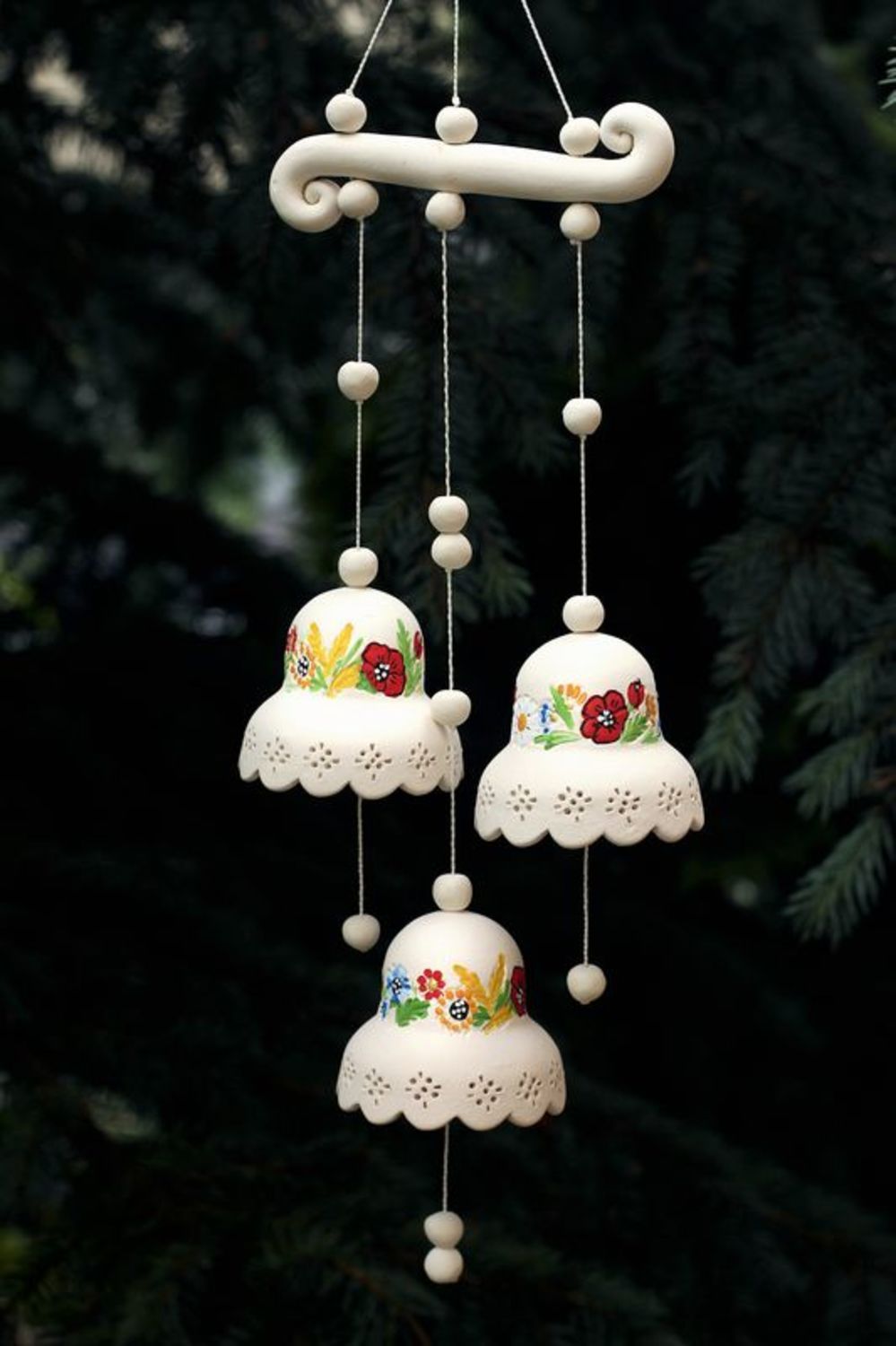 Campanillas de cerámica en un suspensiòn con flores foto 1