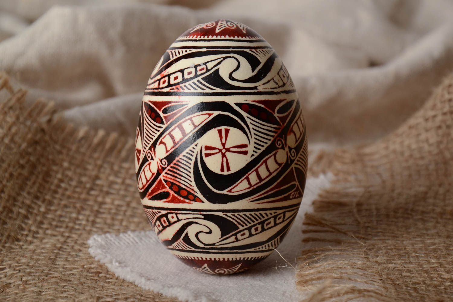 Handmade painted goose egg of black white and red colors ornamented using waxing technique photo 1