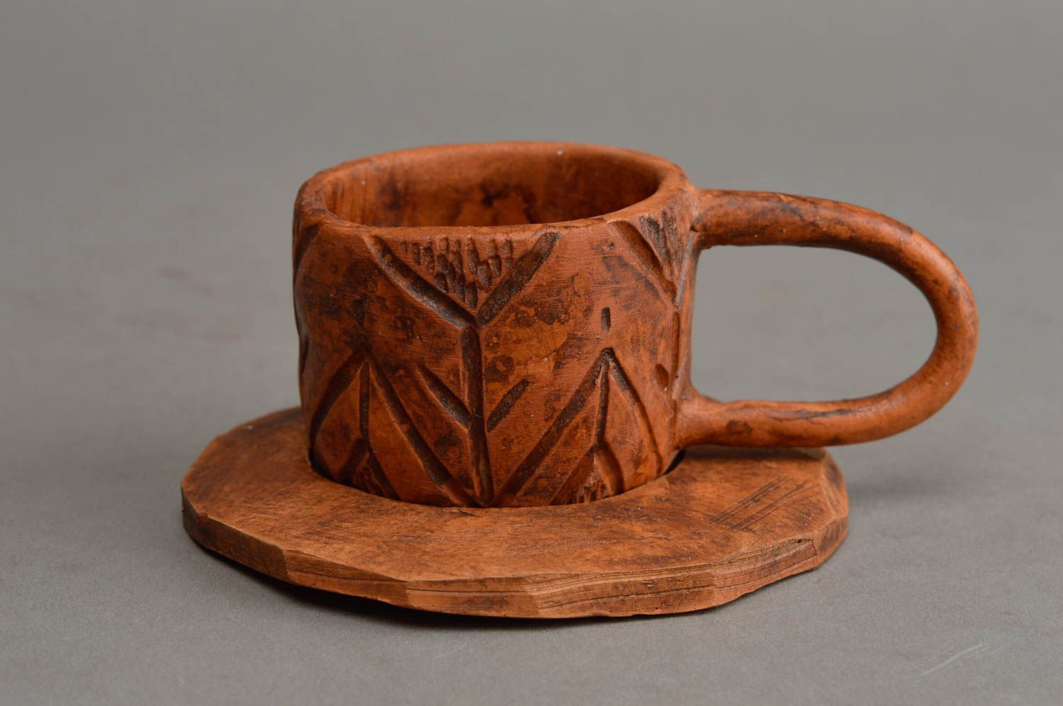 Handgemachte braune keramische Tasse und Untertasse mit Muster für Kaffee foto 2