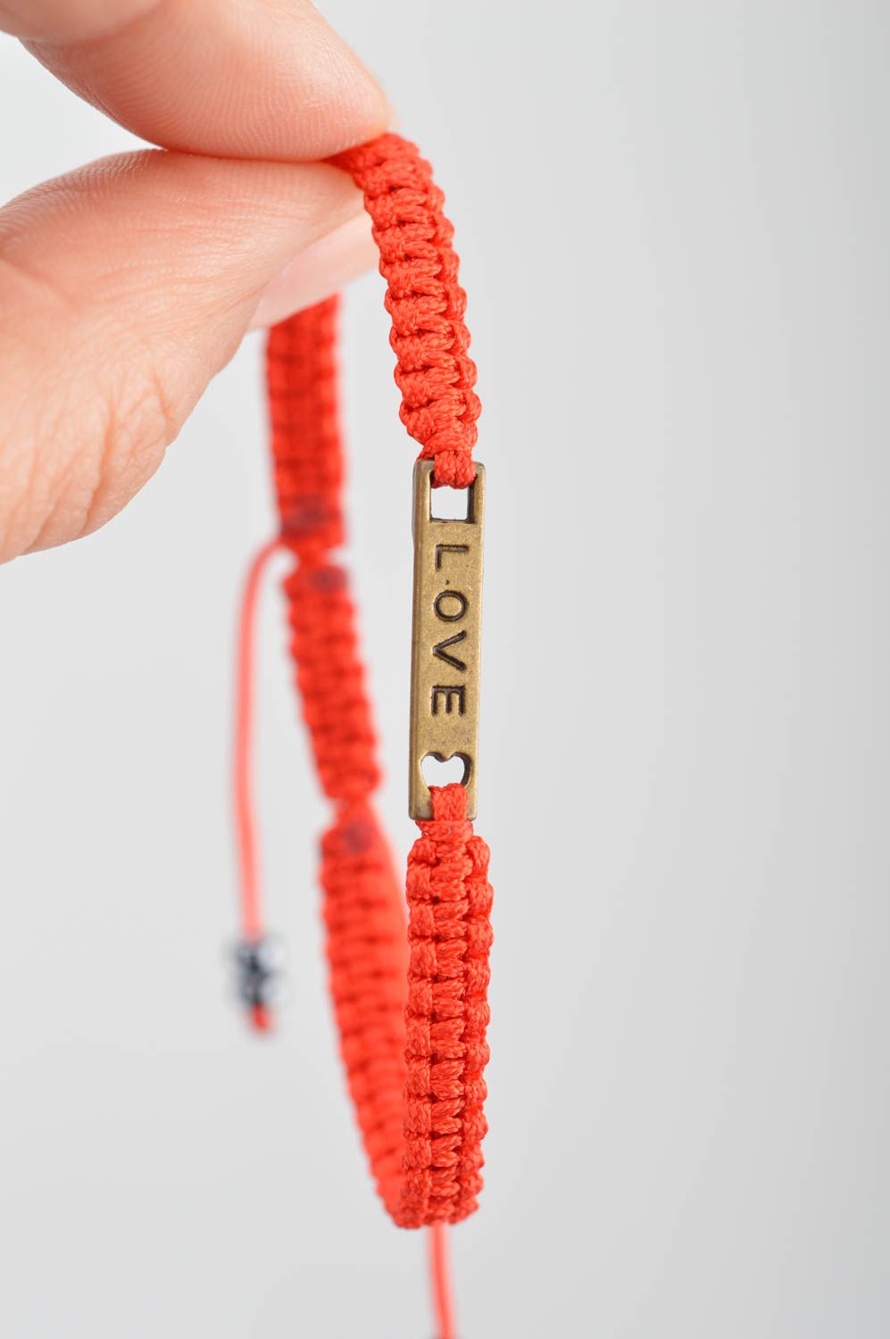 Красный браслет из шелковых ниток с металлической табличкой ручной работы фото 2