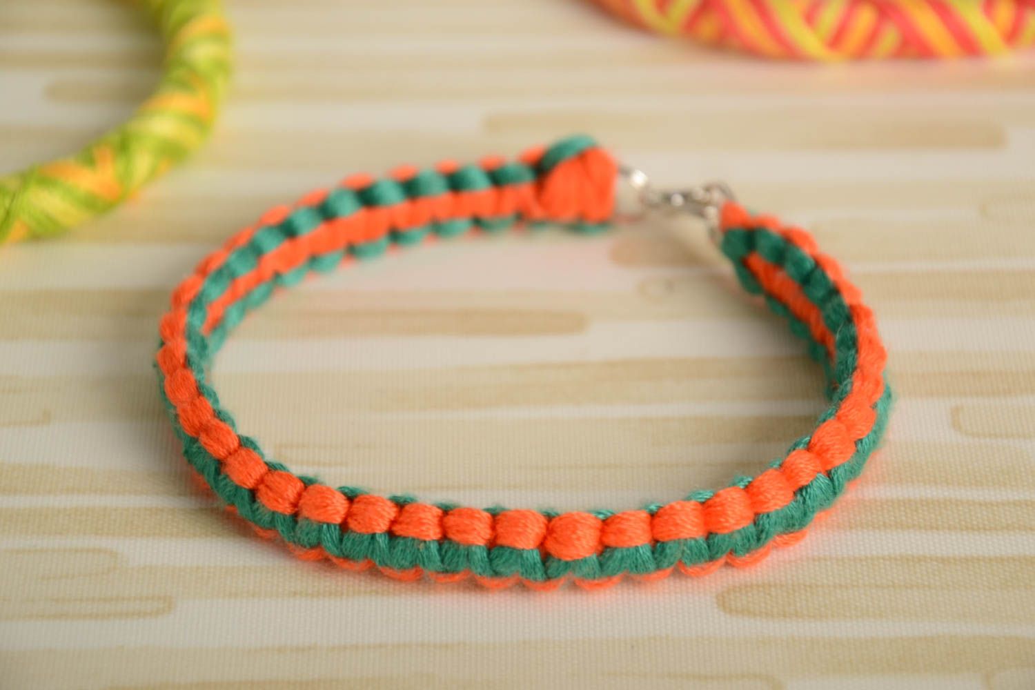 Плетеный браслет из ниток мулине ручной работы тонкий красивый оранжево-зеленый фото 1