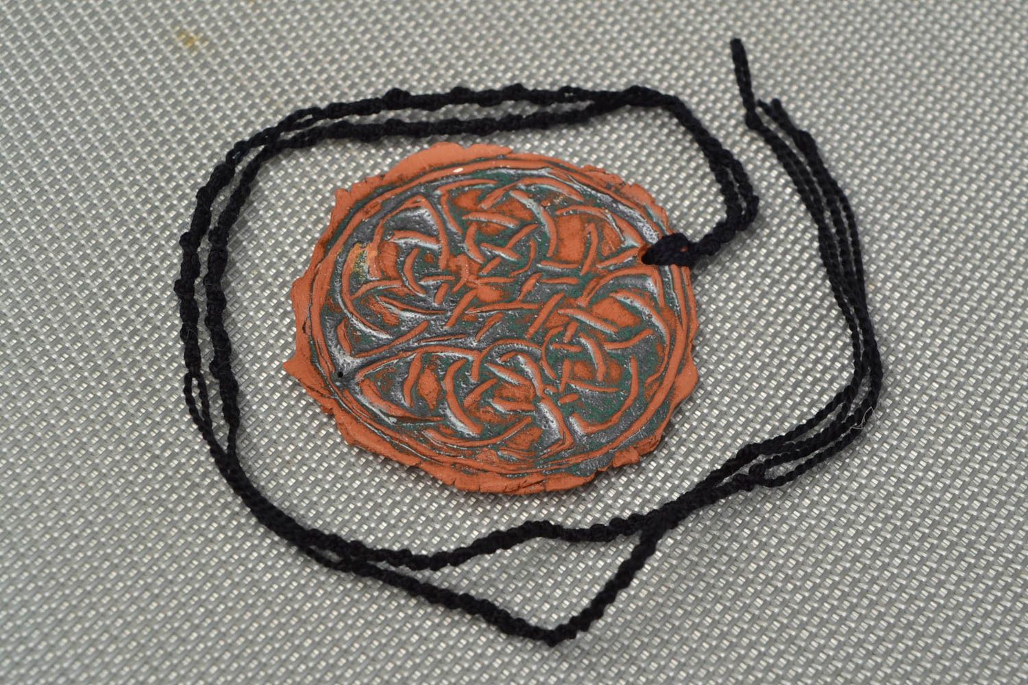Handmade women's designer ceramic round pendant with relief ornament on cord photo 1