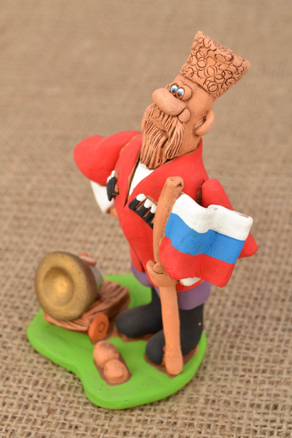 Handgemachte Figurine aus Ton Kosak mit der Kanone und Flagge foto 1
