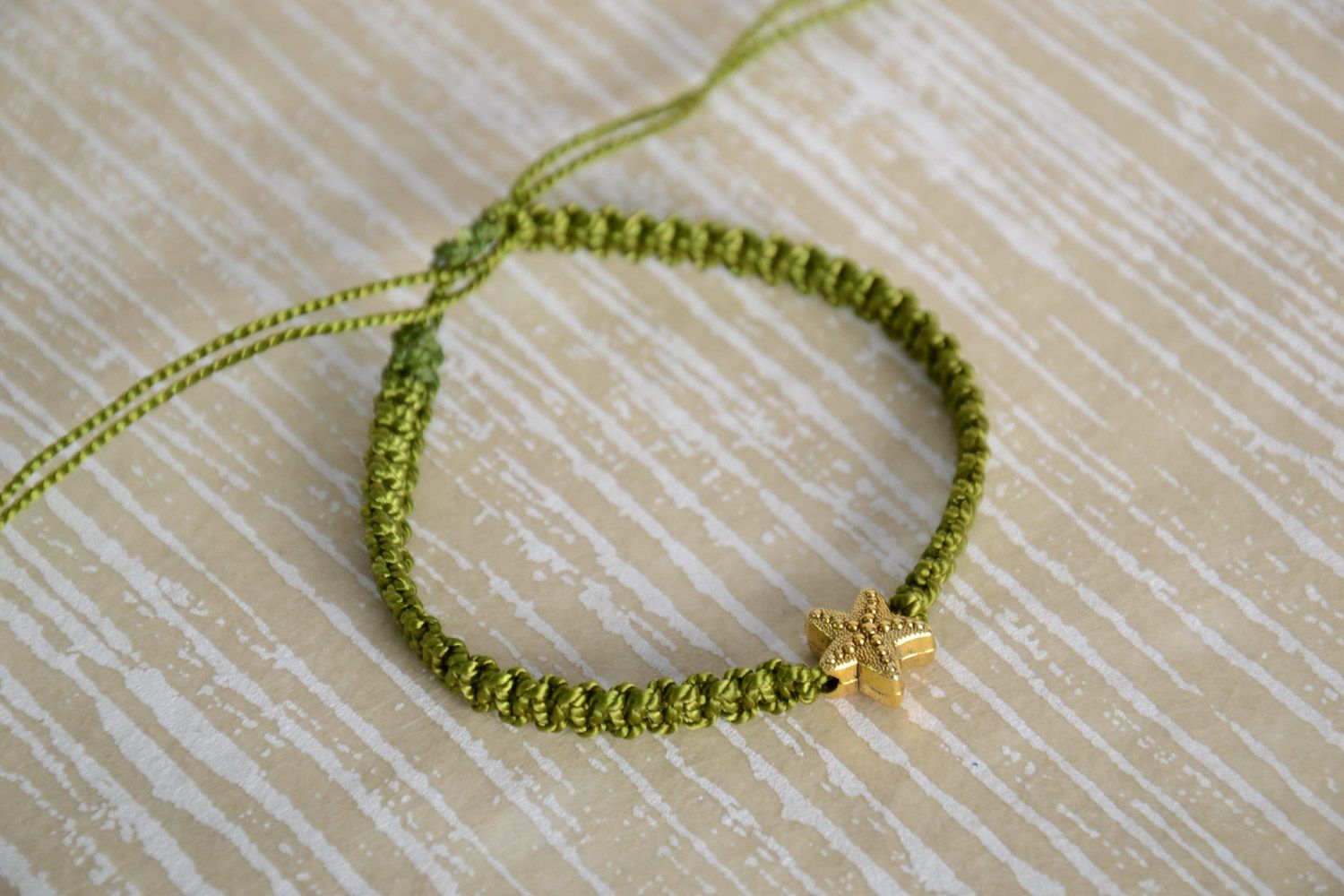 Handmade women's macrame woven bracelet of green color with charm in the shape of star photo 1