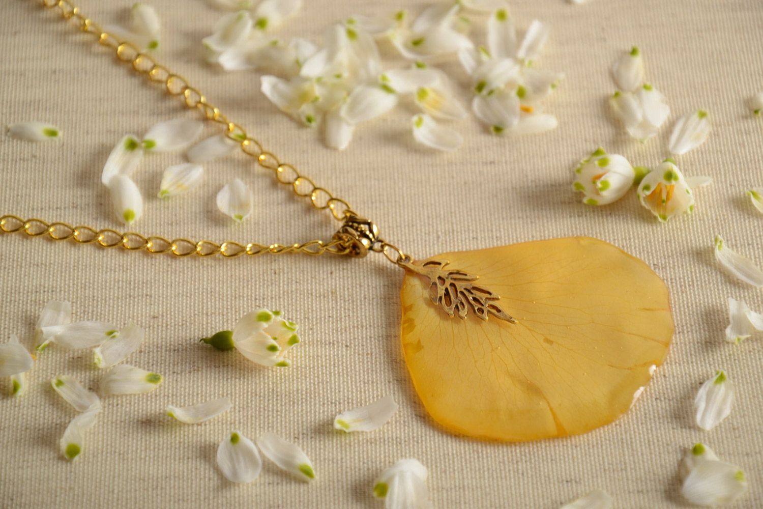 Handmade neck pendant on suede cord with flower petal coated with epoxy resin  photo 1