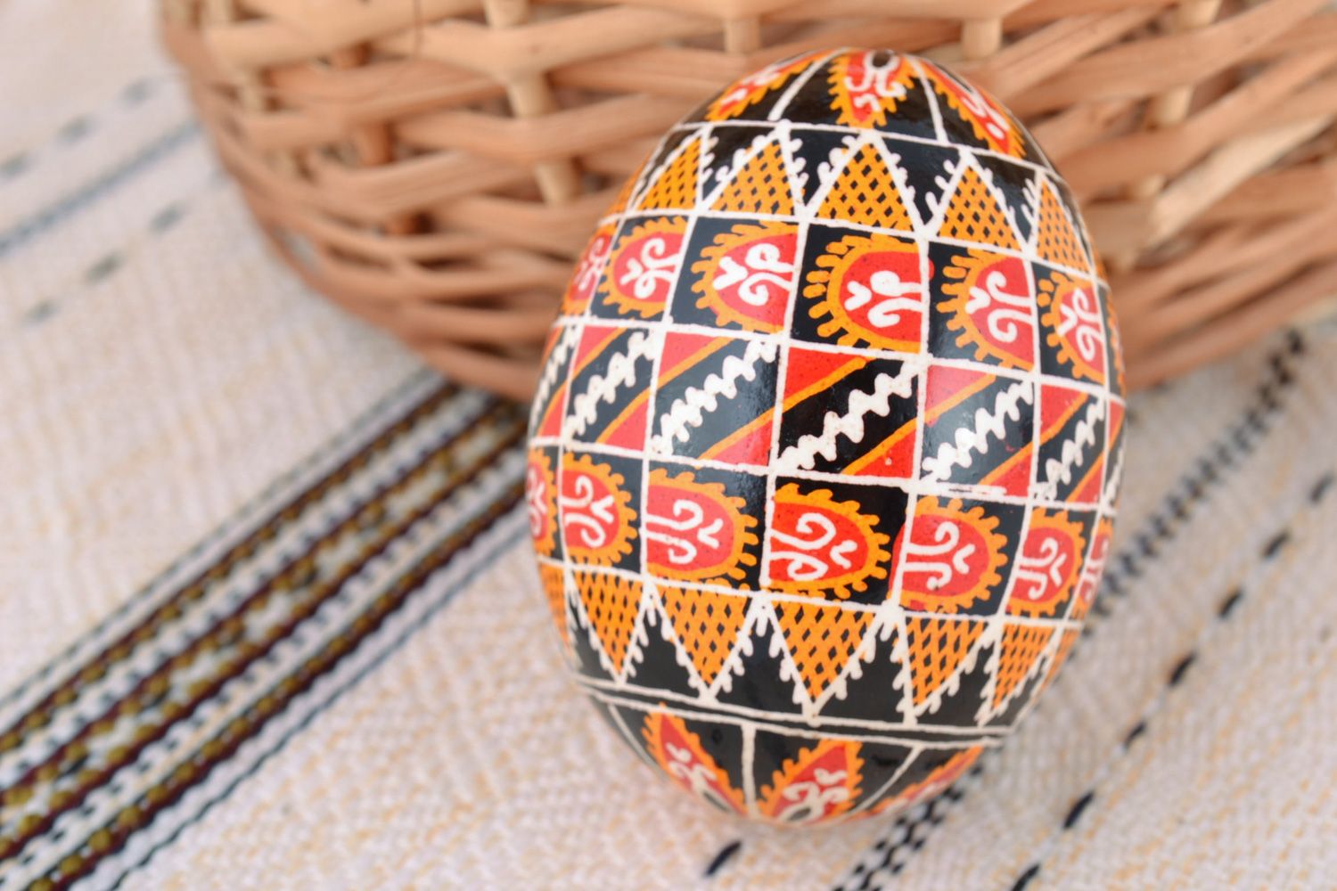 Huevo de Pascua de gallina pintado artesanal con ornamentos en fondo negro foto 1