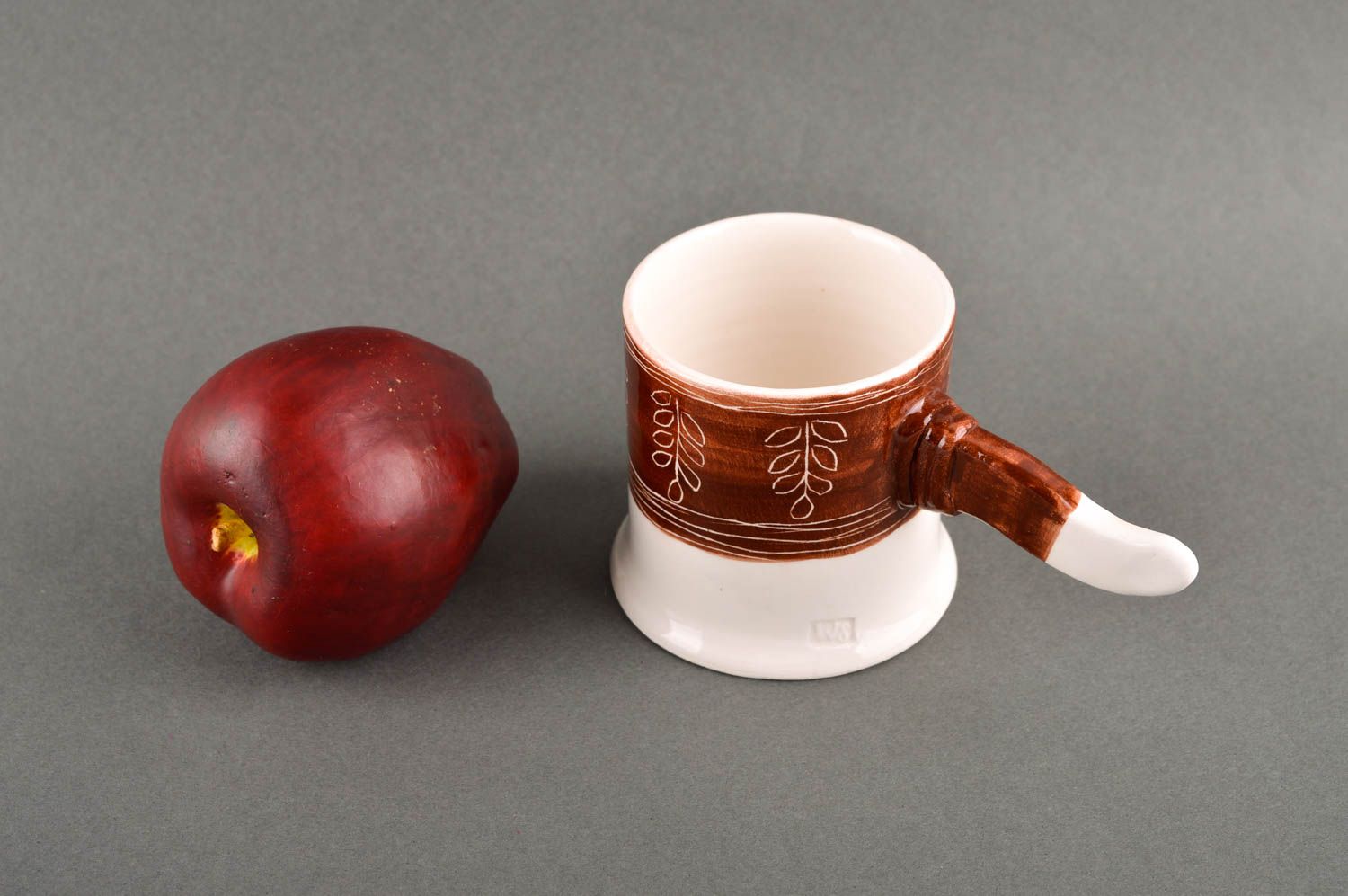 Teacup in white and brown cherry colors and non-standard handle in the shape of a stick photo 1