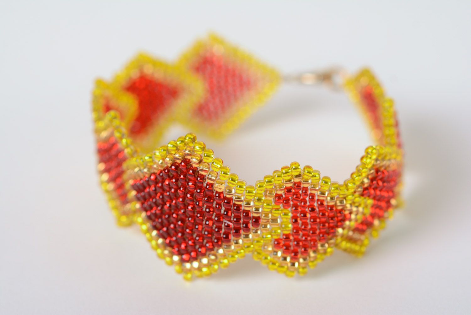 Handmade designer wrist bracelet woven of beads in yellow and red colors  photo 1