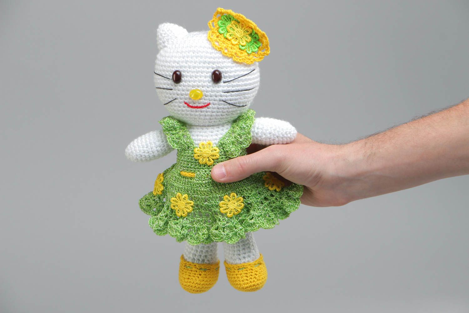 Soft handmade decorative crocheted toy cat in a green dress made of acrylic threads photo 5