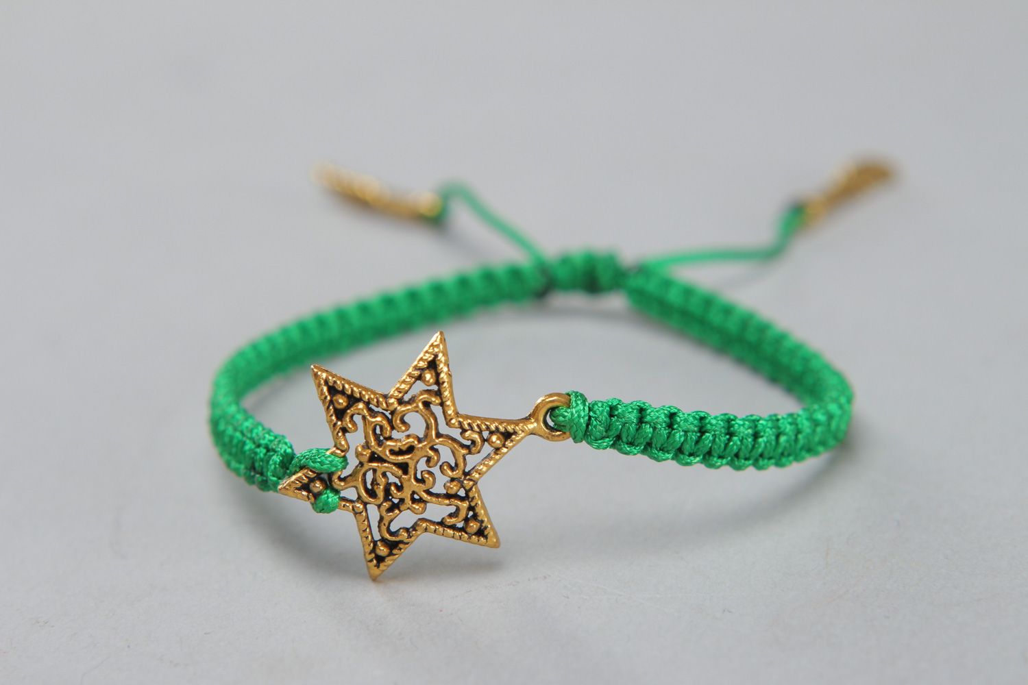 Handmade friendship bracelet woven of green cord with metal star for girls photo 1