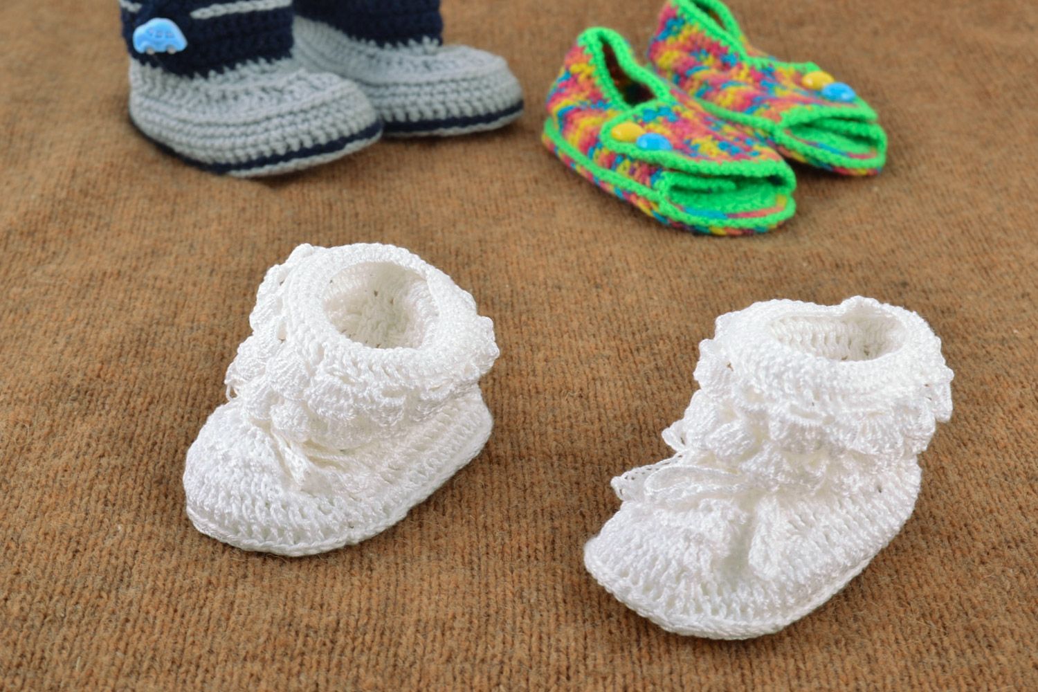 White handmade baby booties knitted of wool and cotton in the shape of shoes photo 1