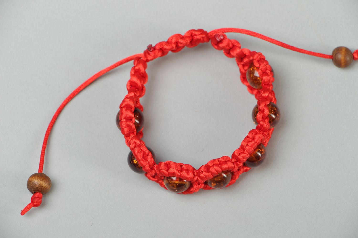 Красный плетеный браслет с бусинами фото 1