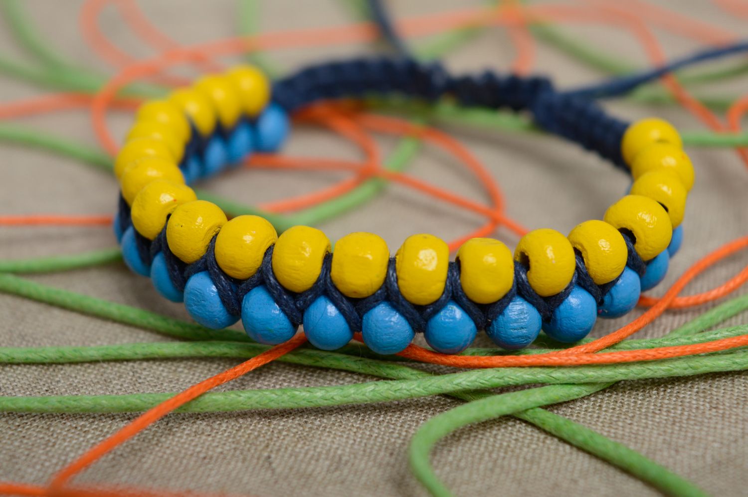 Bracelet technique macramé en perles de bois et lacet ciré fait main bleu-jaune photo 2