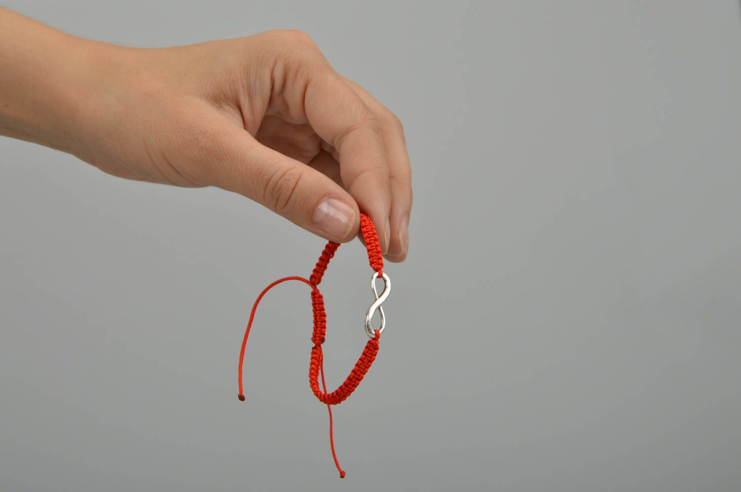 Bracelet tressé rouge en lacet ciré et symbole de l'infini en métal fait main  photo 2