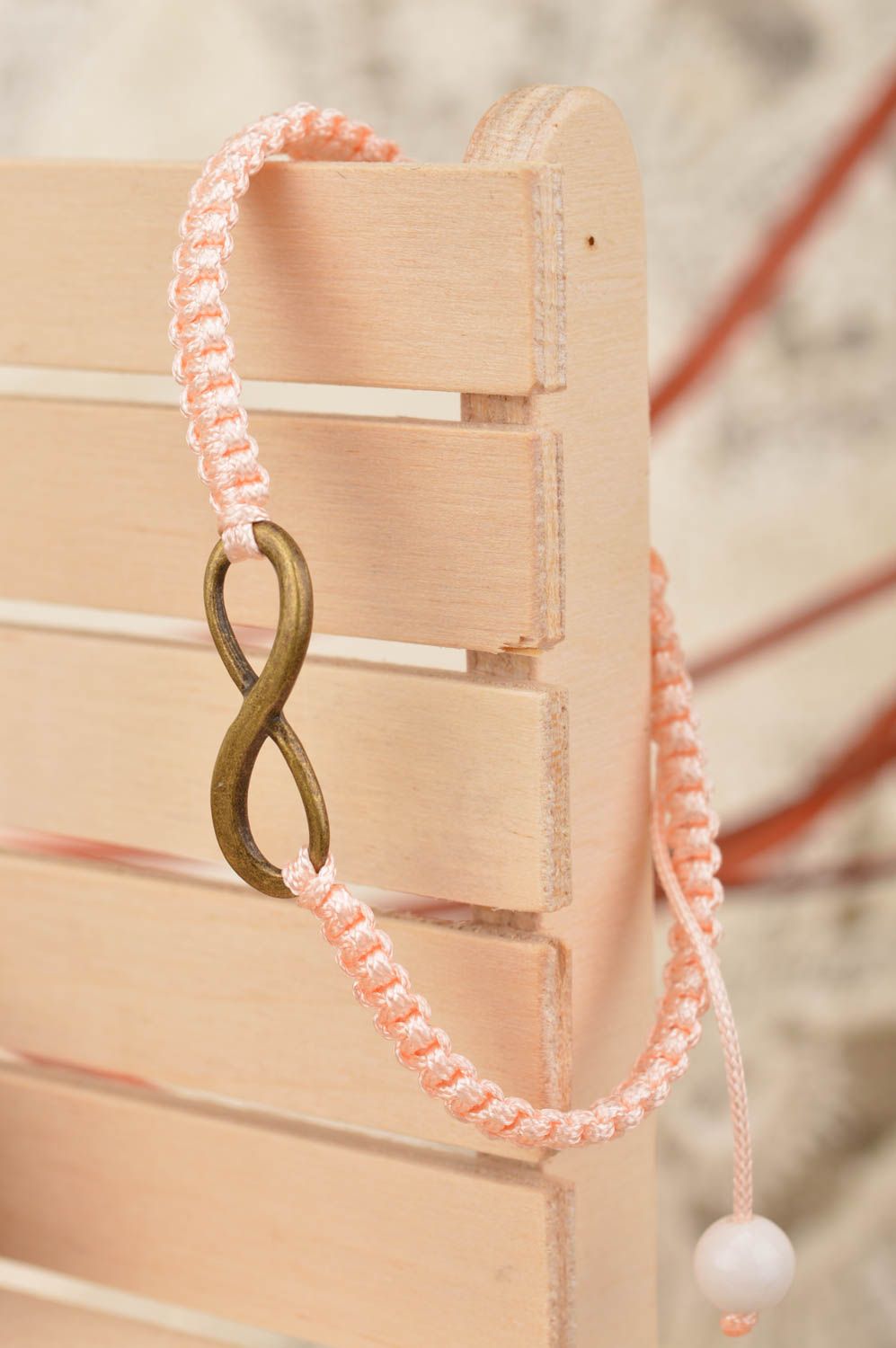 Handmade stylish thin pink woven wrist bracelet made of silk with insert photo 1