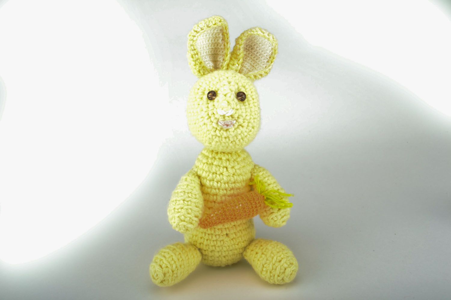 Brinquedo de malha na forma de um coelho com uma cenoura foto 1