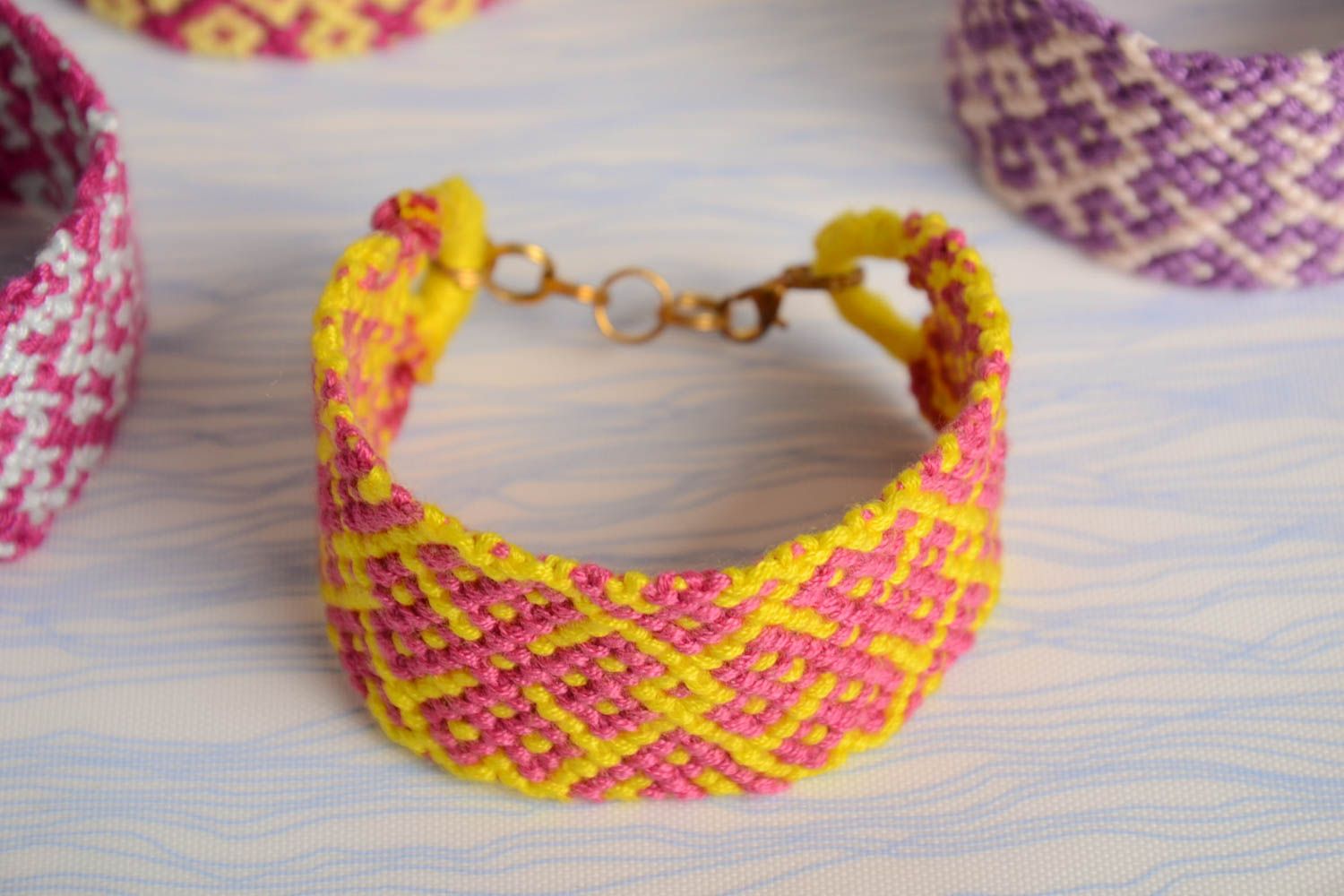 Широкий яркий плетеный браслет из ниток мулине ручной работы розово-желтый фото 1