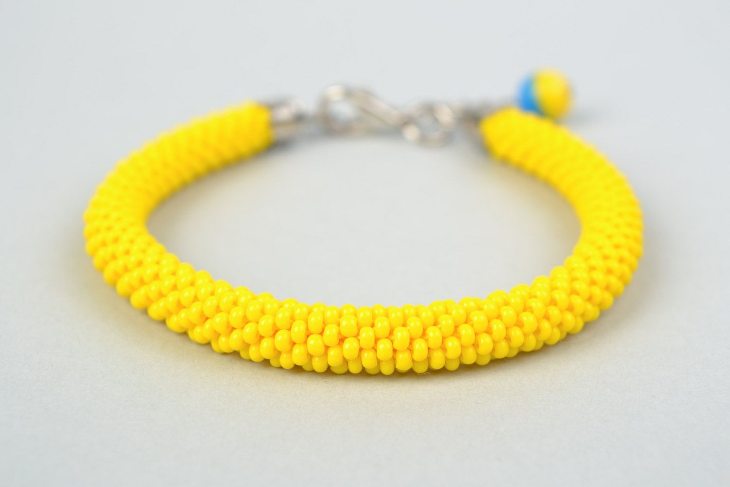 Handmade cord bracelet crocheted of bright yellow Czech beads with blue charm photo 2