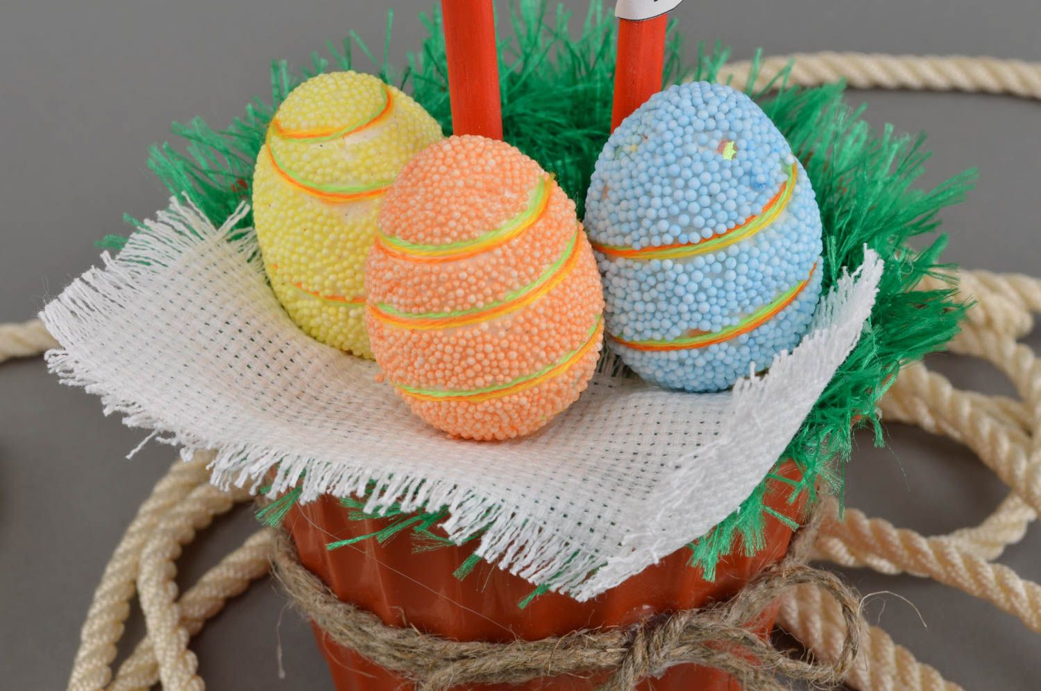 Interior beautiful cute toy hen on basket with orange yellow and blue eggs photo 4