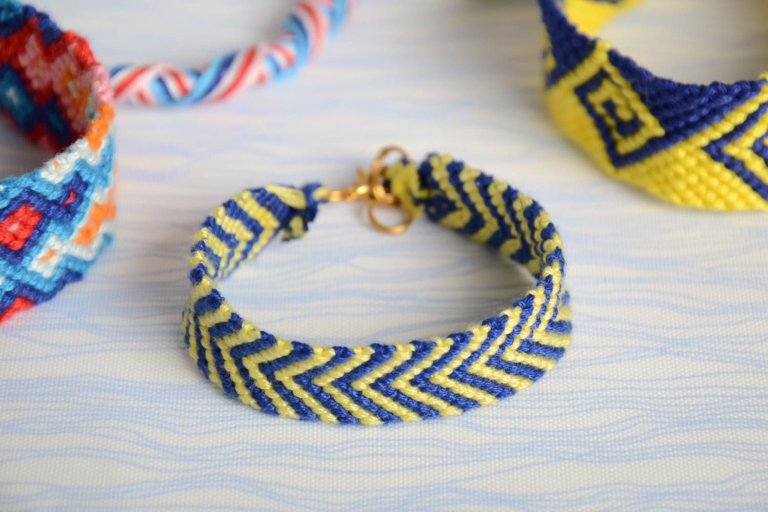 Künstlerisches gelb blaues geflochtenes Armband aus Fäden Mulinee eng handmade foto 1