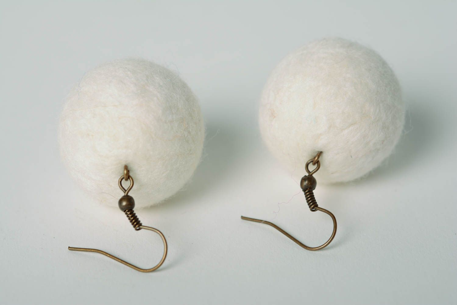 White handmade wool ball earrings created using needle felting technique photo 1