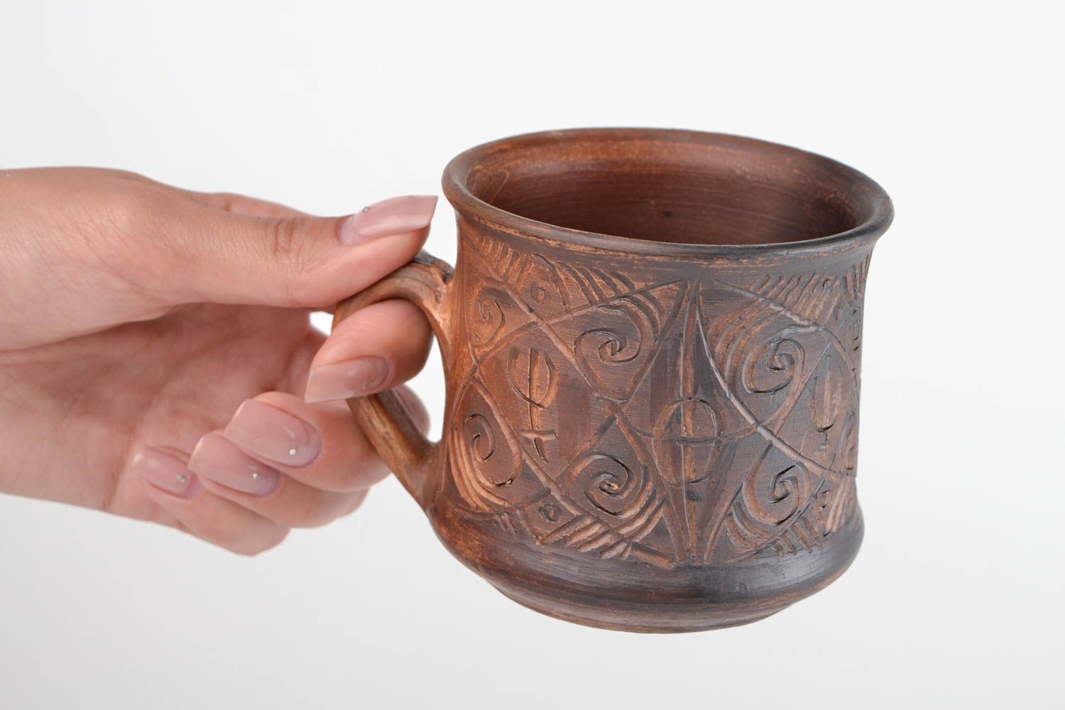 Clay cup for drinks in brown color with handle and cave symbols photo 2
