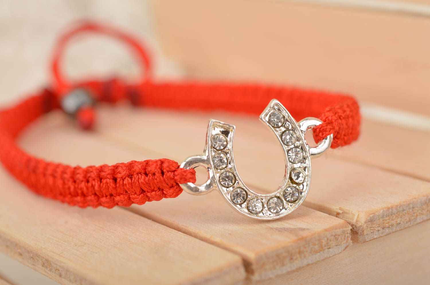 Dünnes rotes geflochtenes Armband aus Faden mit metallischem Hufeisen für Glück foto 1