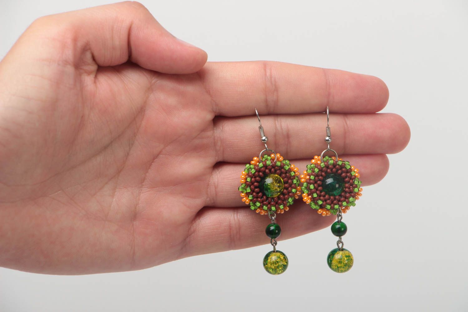 Schöne originelle grüne handgemachte Ohrringe aus Glasperlen und Metall foto 5