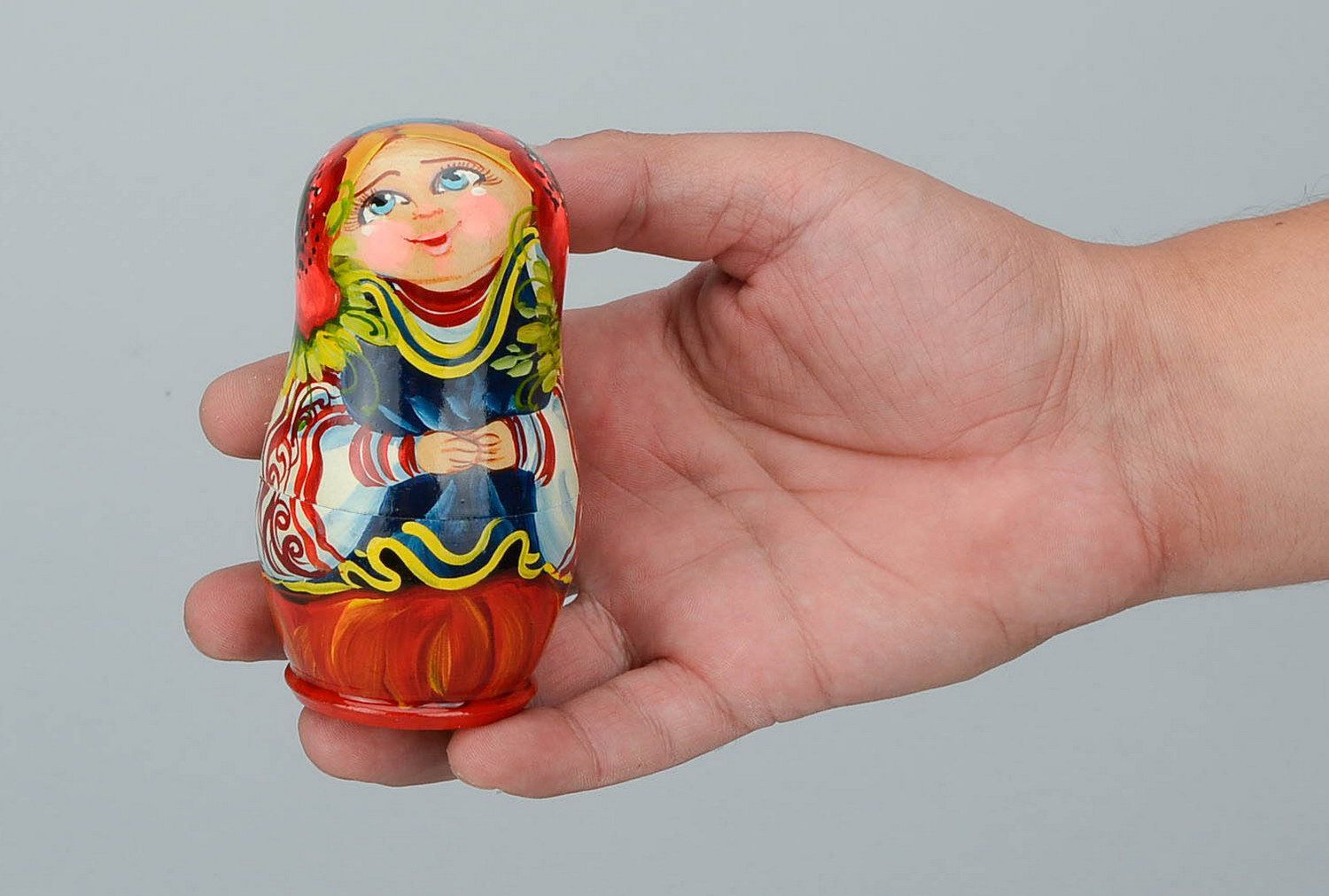 Matrioshka en Amapolas. Matrioshka es una muñeca de madera con vestido ruso campesino, que contiene otras de menor tamaño
 foto 1