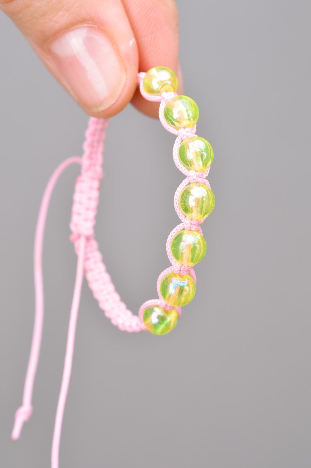 Beautiful stylish handmade children's bracelet woven of threads and beads of gentle pink color photo 3