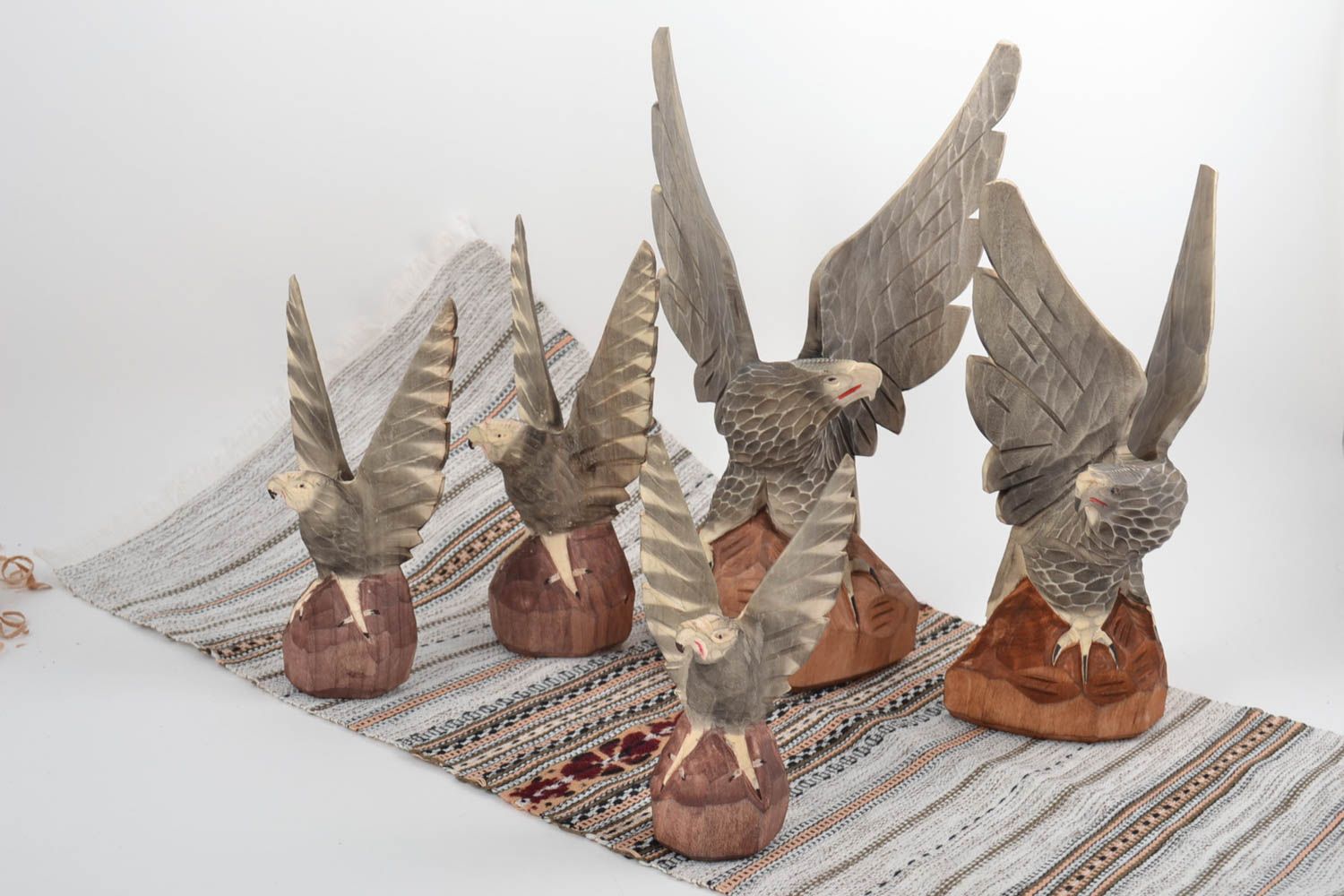 Conjunto de figuras de madera hechos a mano con forma de águilas de diferentes tamaños foto 1