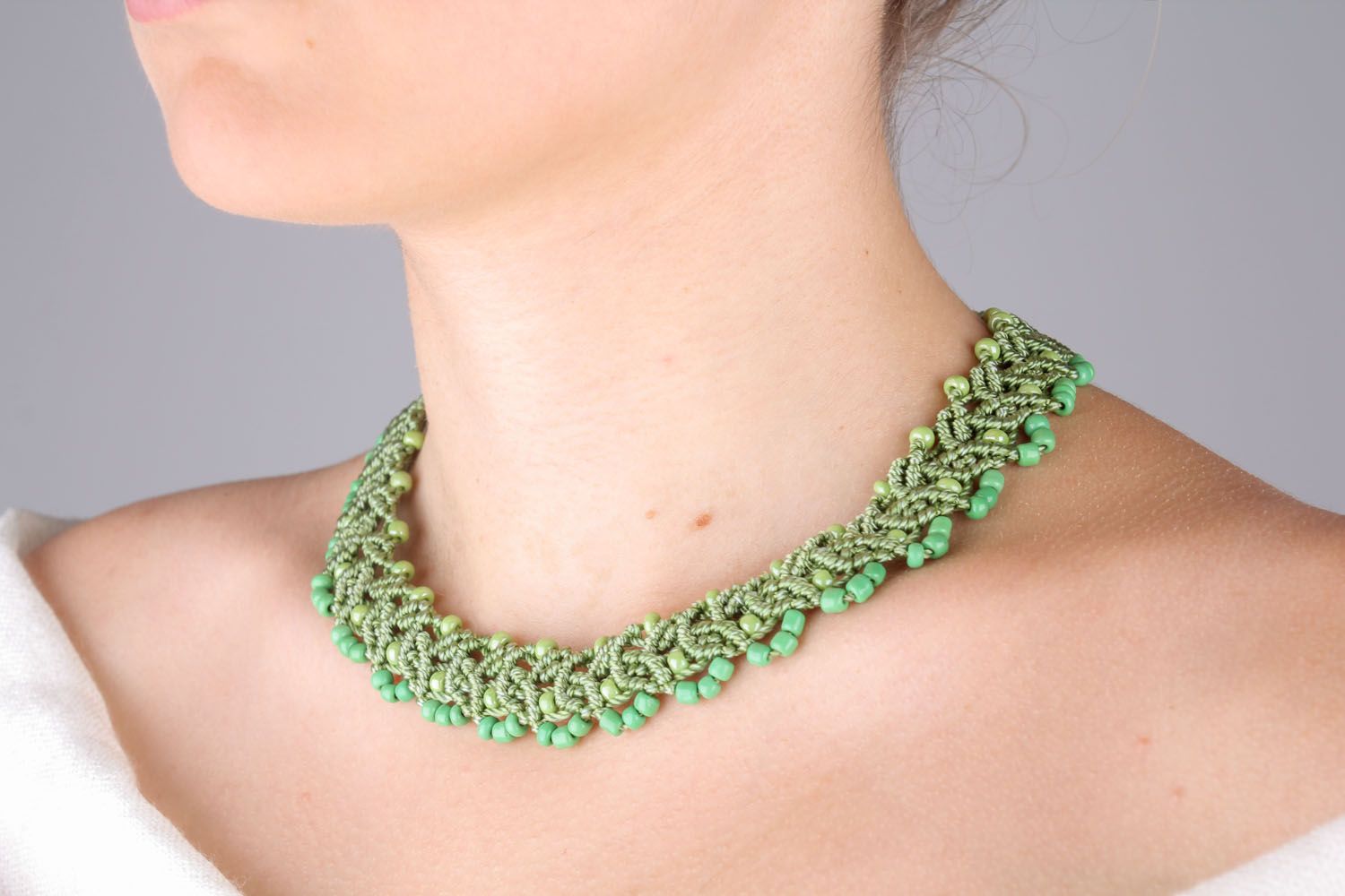 Green necklace made of threads and beads photo 1