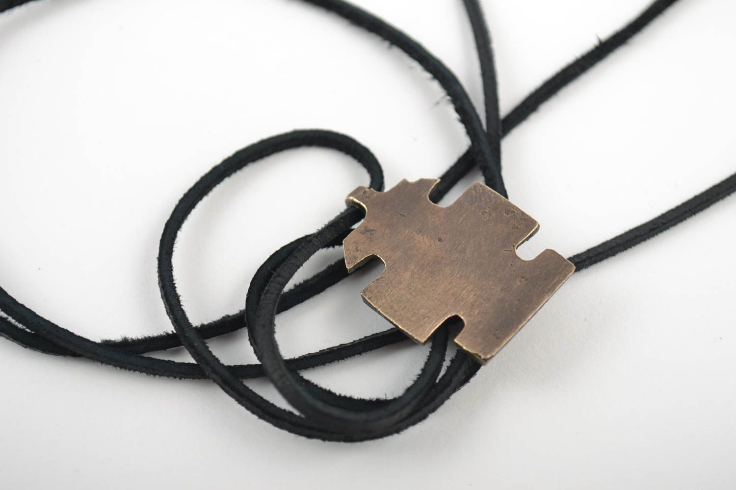 Pequeña cruz de bronce para el cuello hecha a mano en cordón foto 4