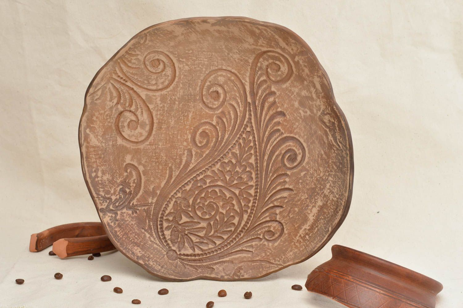 Assiette plate en terre cuite marron clair avec motif en relief ronde faite main photo 1