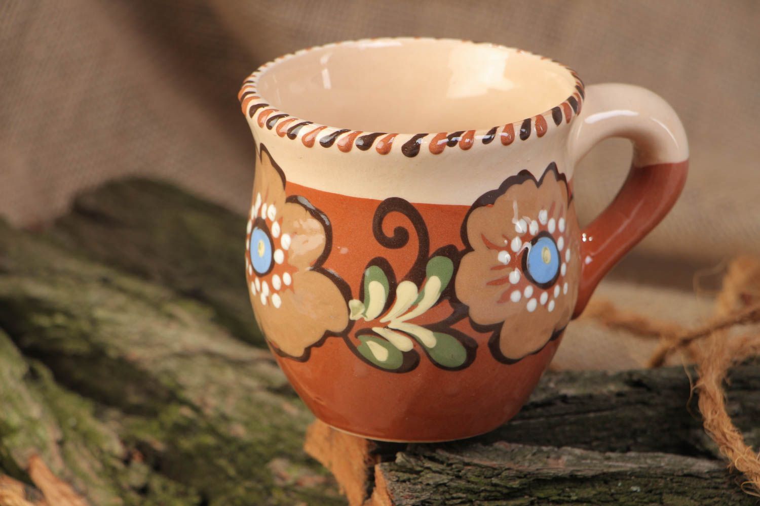 Decorative clay cup with handle and floral pattern in brown and beige color photo 1