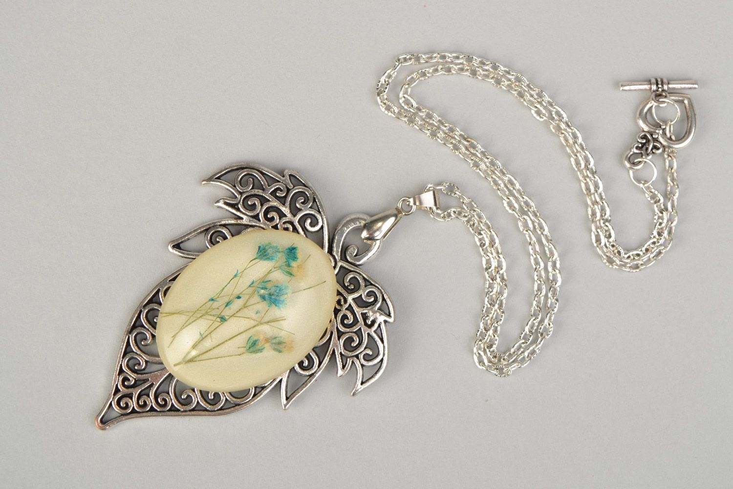 Handmade lacy leaf-shaped pendant with natural flowers in epoxy resin on chain photo 3