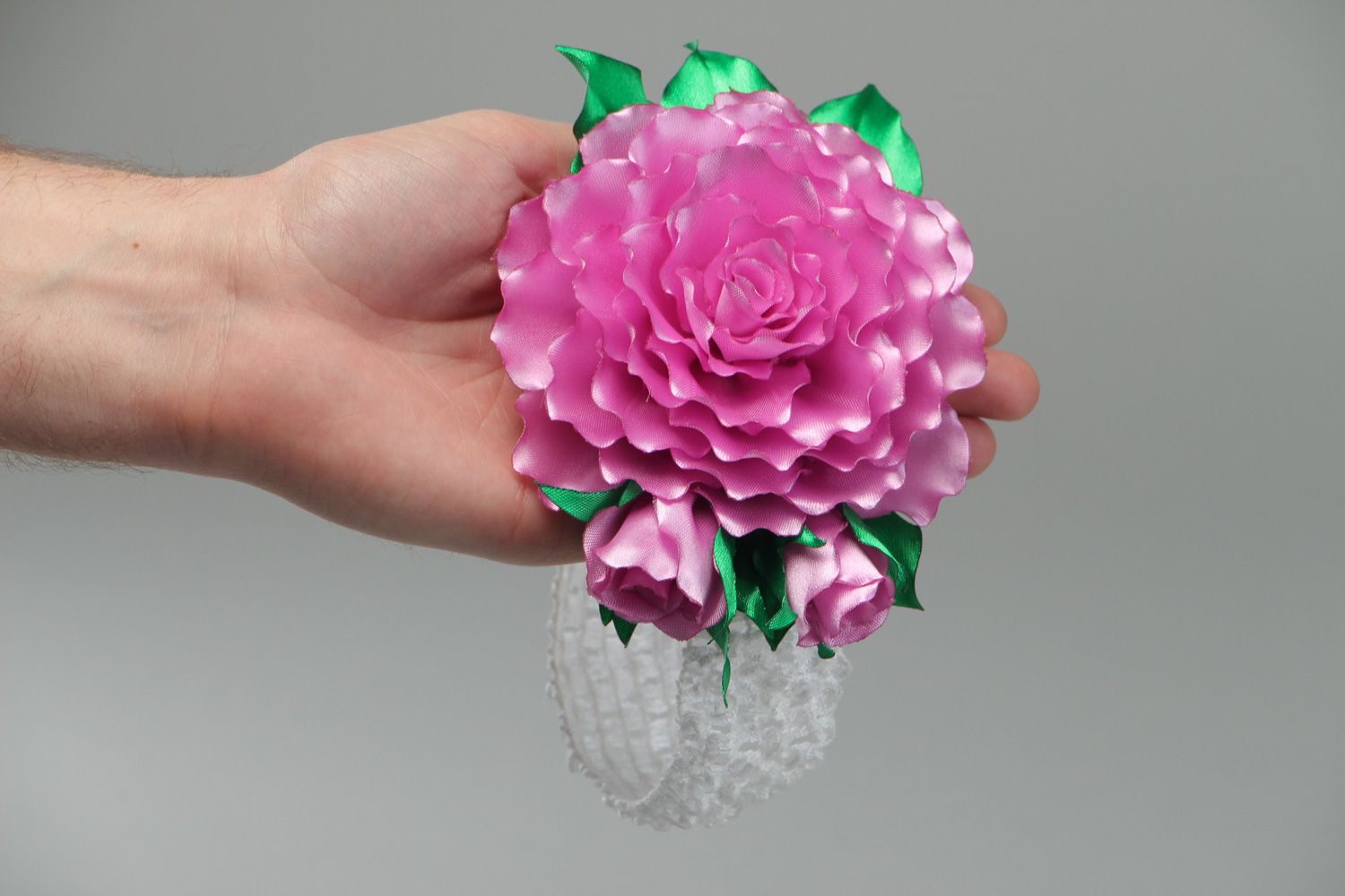 Bright elastic handmade headband with satin flower of pink color with green leaves photo 4