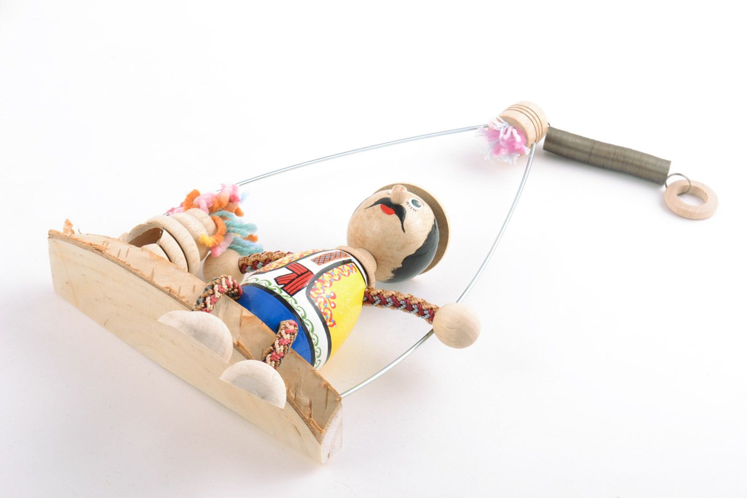 Handmade decorative wooden toy doll on a swing bench hand-decorated with paints photo 5