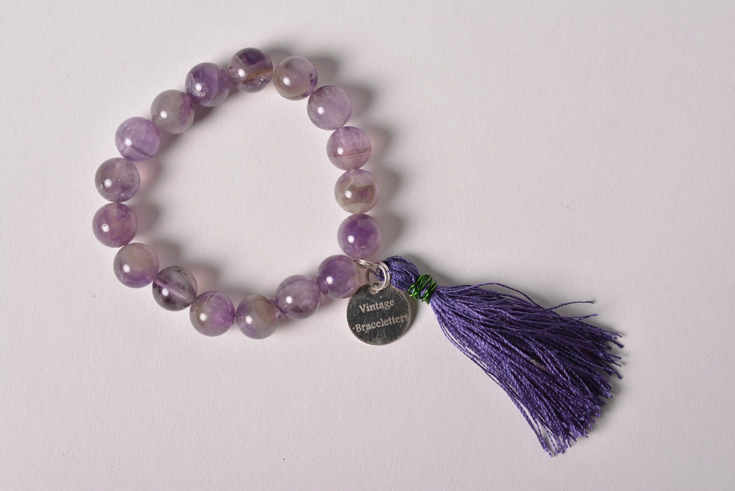Handmade tender wrist bracelet with amethyst beads and thread tassel for women photo 3