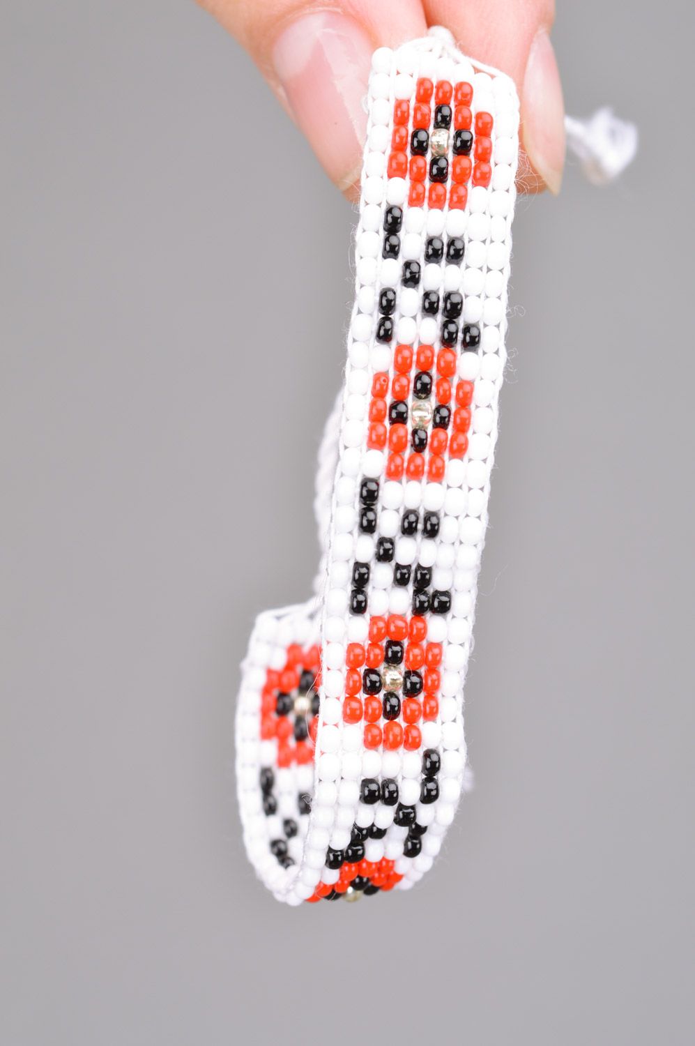 Handmade wrist bracelet woven of black white and red beads with ethnic ornament photo 3