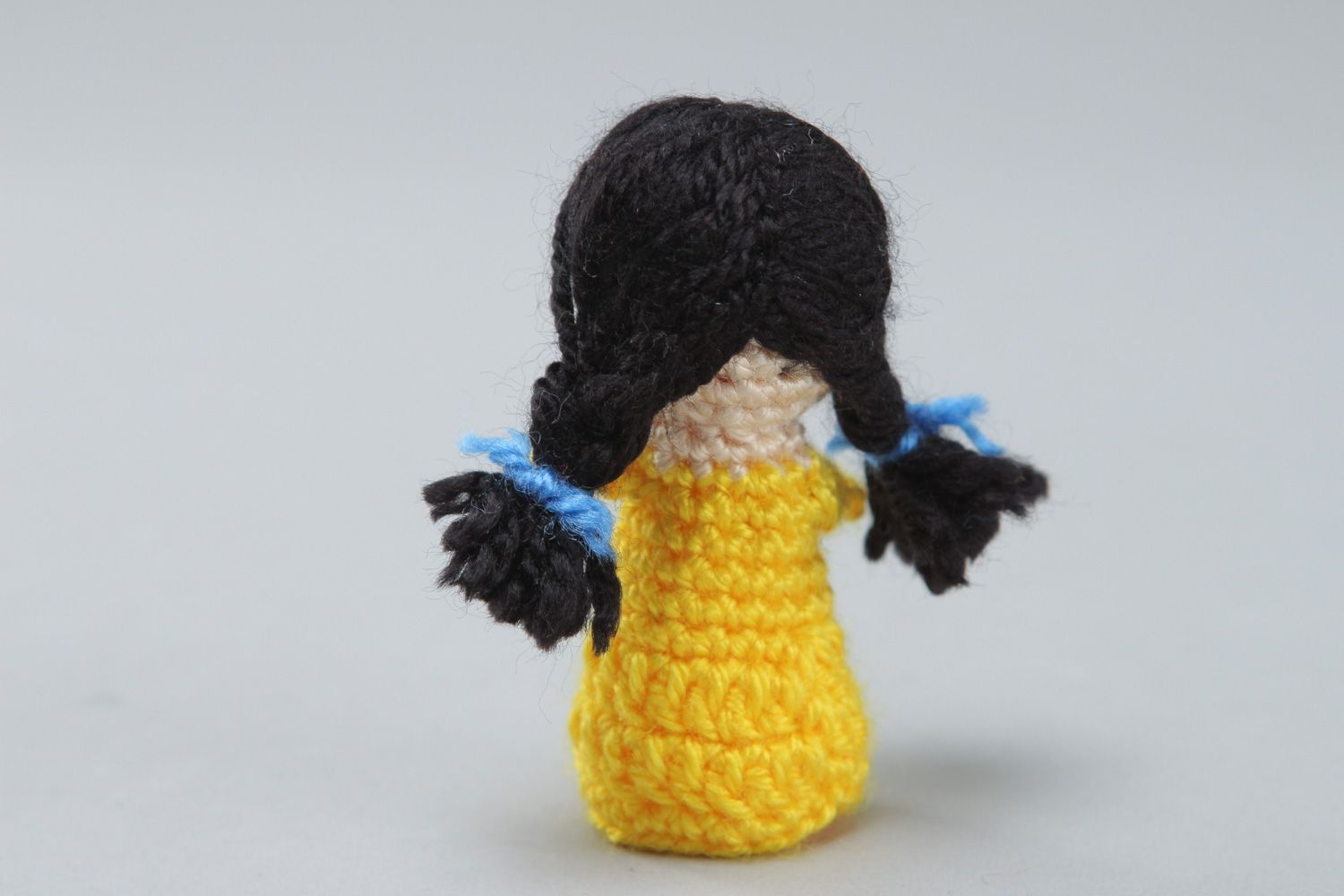 Handmade finger puppet crocheted of acrylic threads girl in yellow dress photo 2