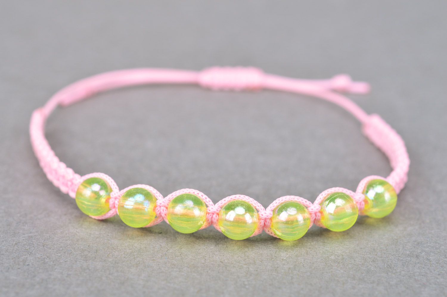 Beautiful stylish handmade children's bracelet woven of threads and beads of gentle pink color photo 2